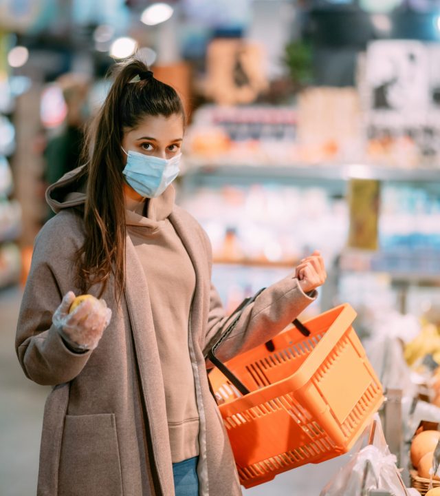 young woman in protective mask makes purchases